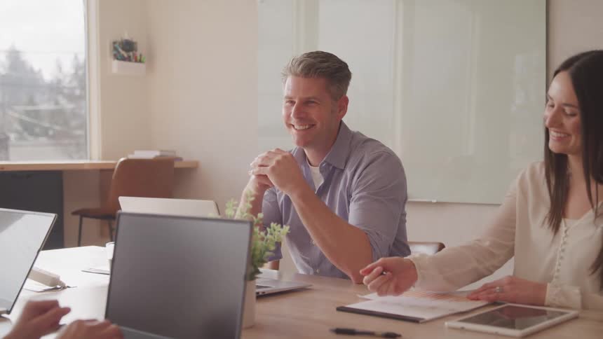 A footage of a man and a woman in the office sharing a conversation on a round table