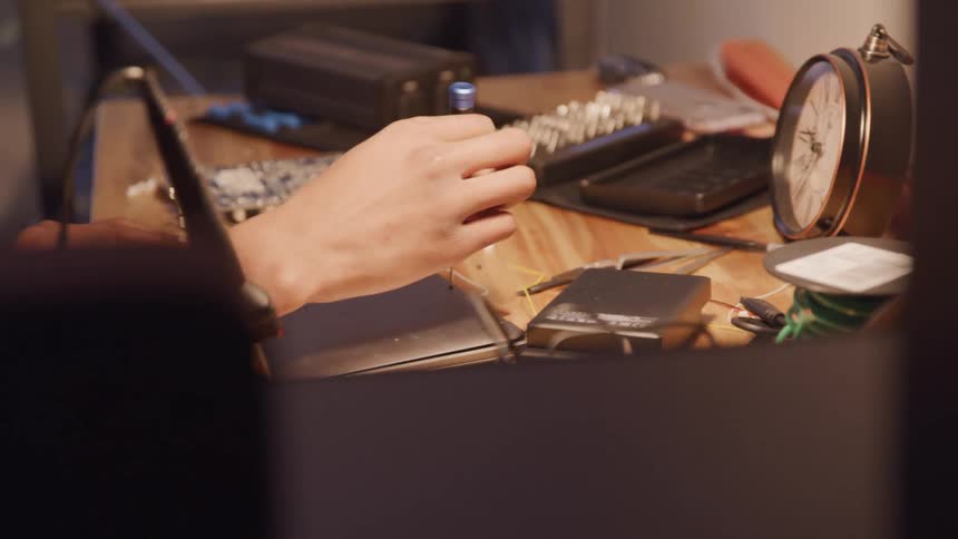 Closeup of an adult removing a screw from the back of an electronic tablet