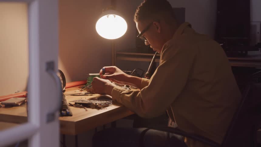 Man working on computer hardware removes a small screw