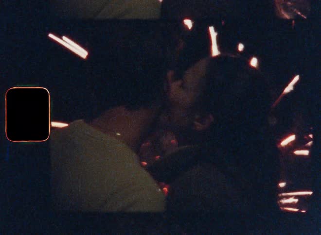 A man and woman kiss while the fireworks go off