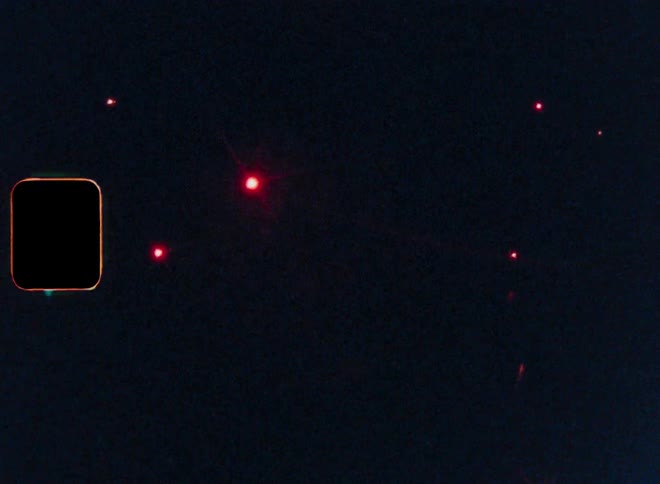 Red fireworks explode in the night sky