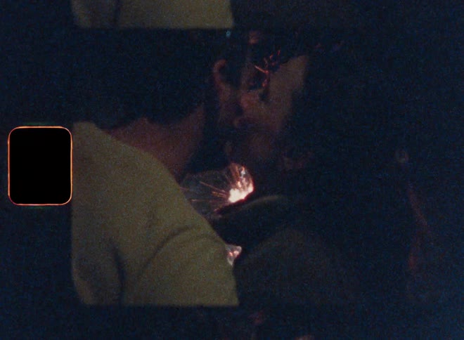 Woman kissing her boyfriend while watching fireworks at night