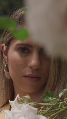 Portrait of a woman among green leaves outdoors