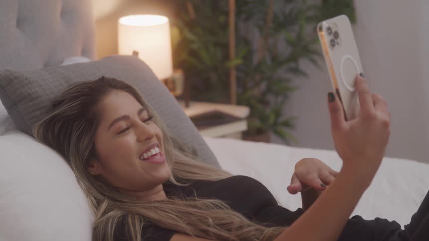 A woman talks and laughs as she talks to someone on her phone