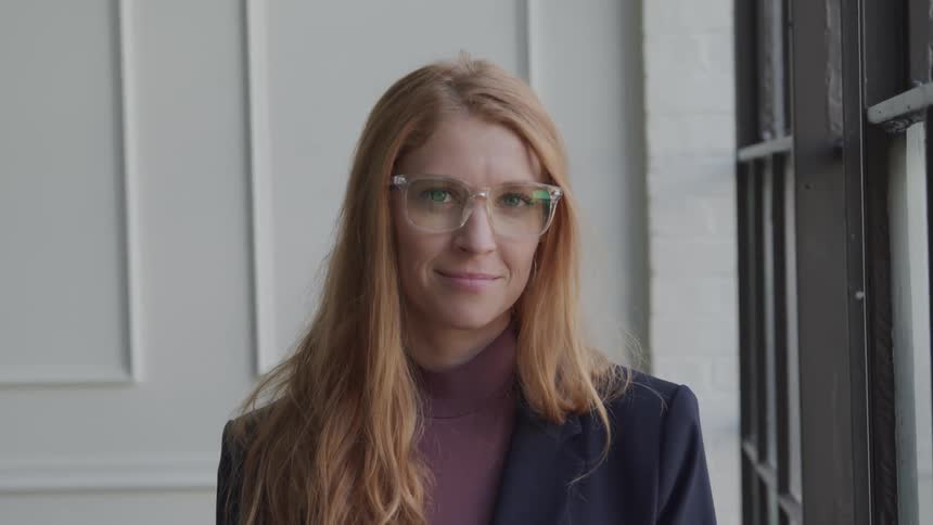 A woman is smiling by the window
