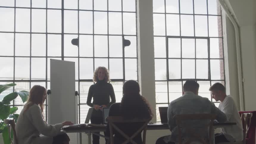 Four students are asking a teacher questions while in art class