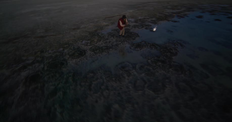 A man is dancing by the lake at sunrise
