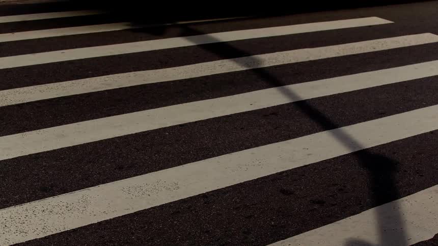 A bustling intersection with pedestrians navigating crosswalks and vehicles flowing through