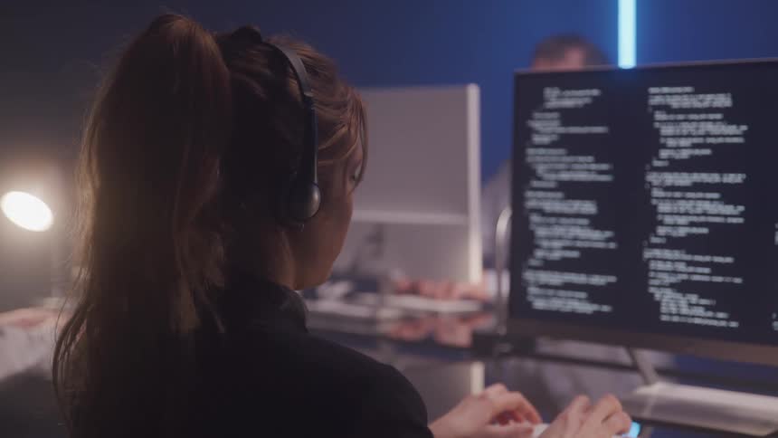 A footage of a lady typing on a computer in the office