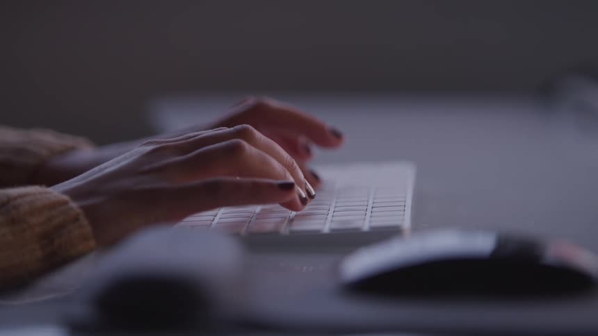 A person is typing on a computer keyboard
