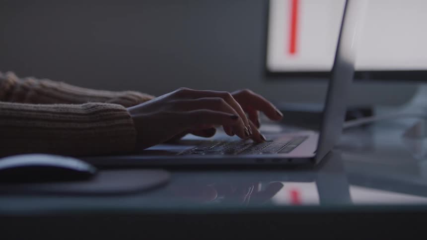 Pair of hands typing on a laptop