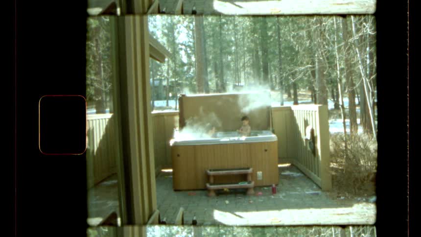 Two people inside an outdoor hot tub with smoke coming out