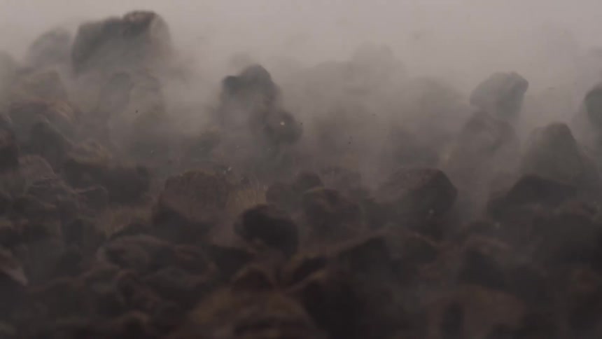 Ground shaking and rocks being tossed around on the side of a mountain