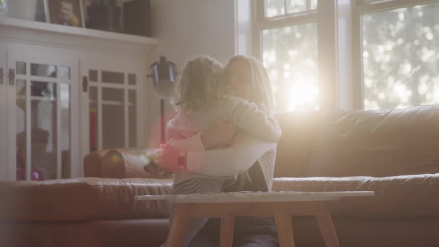 A little girl moves to her mother for a hug