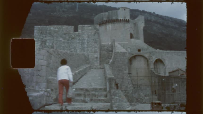 A woman climbs up the steps of the castle