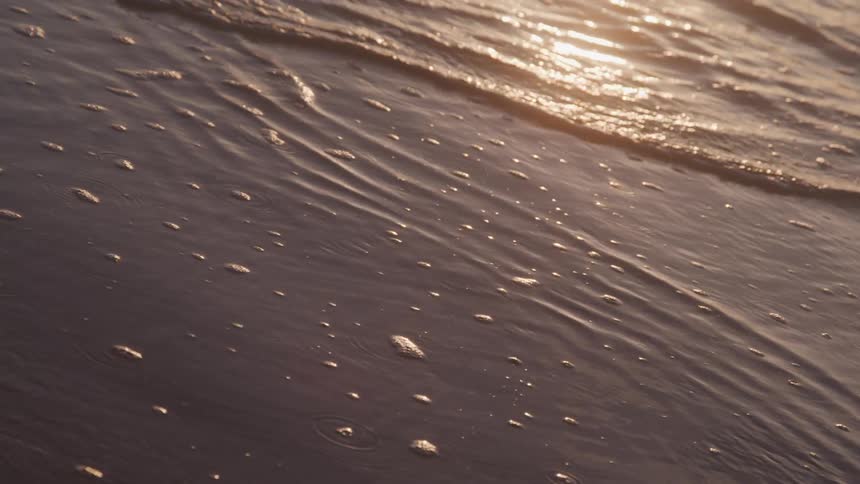 Close up of calm waters on the edge of the sand on the beach