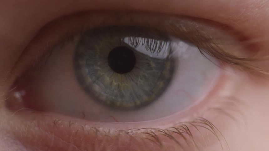 An eye opening and closing with the light reflecting in the iris and showing off the lashes