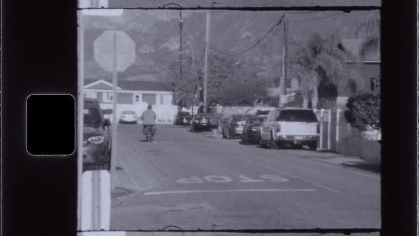 Woman rides a bicycle along a residential street during the daytime