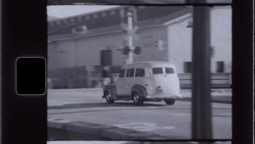 Old and classic car driving down a street