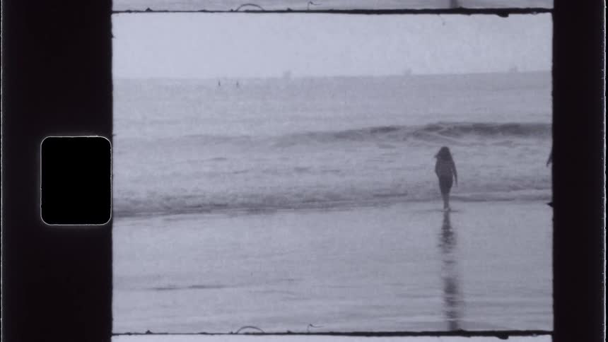 Two people wading in the ocean