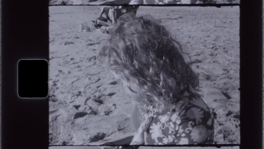 A little girl is playing in the sand at the beach