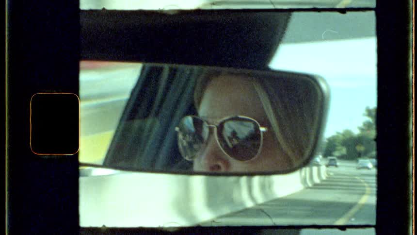 A woman is driving a car on the highway