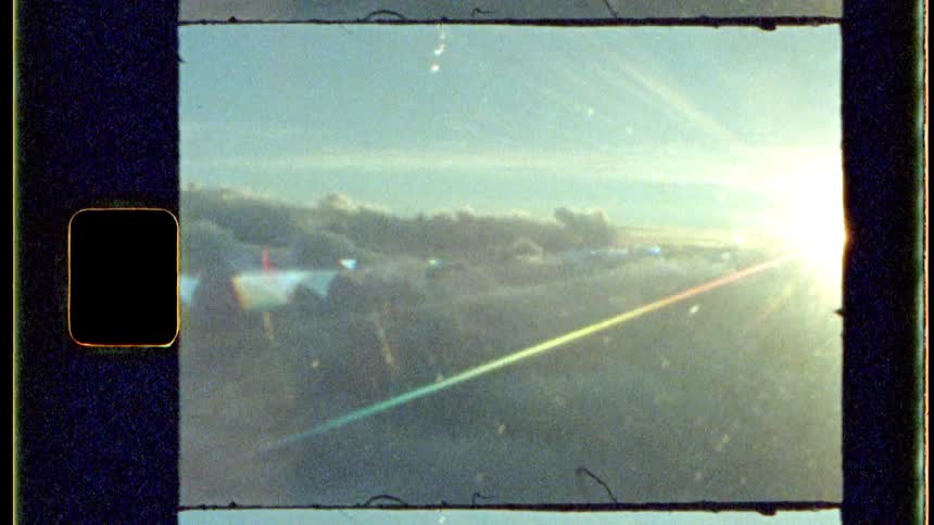 Sun glares over the clouds in the sky outside a window