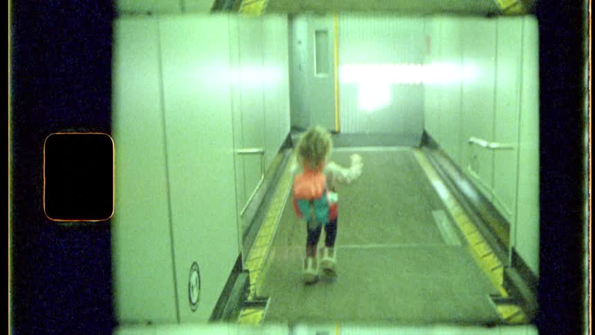 A little girl is running down a hallway