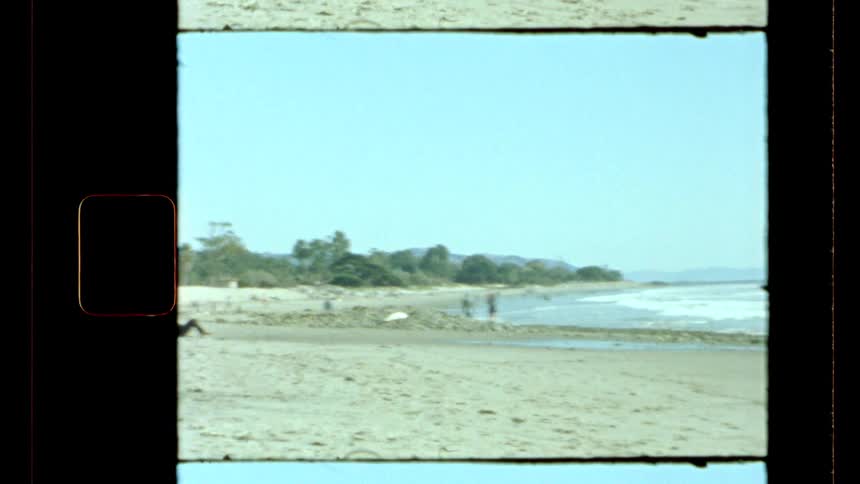 People are walking and laying on a beach