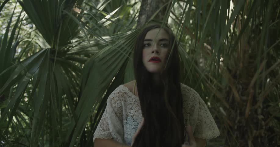 Long hair woman brushes hair back from her face