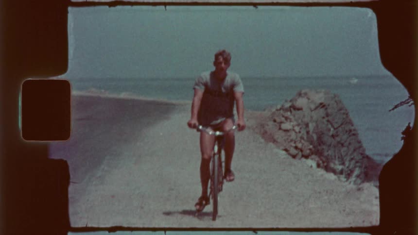 Man pedals on his bicycle along the beach on a summer day