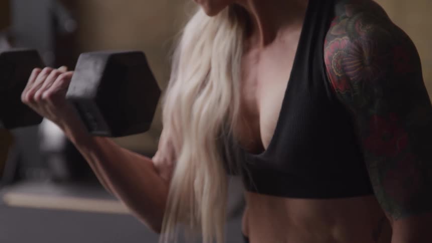 A woman is lifting weights in the gym