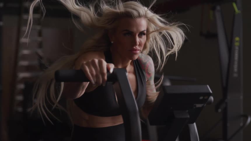 Blonde woman doing elliptical in a gym