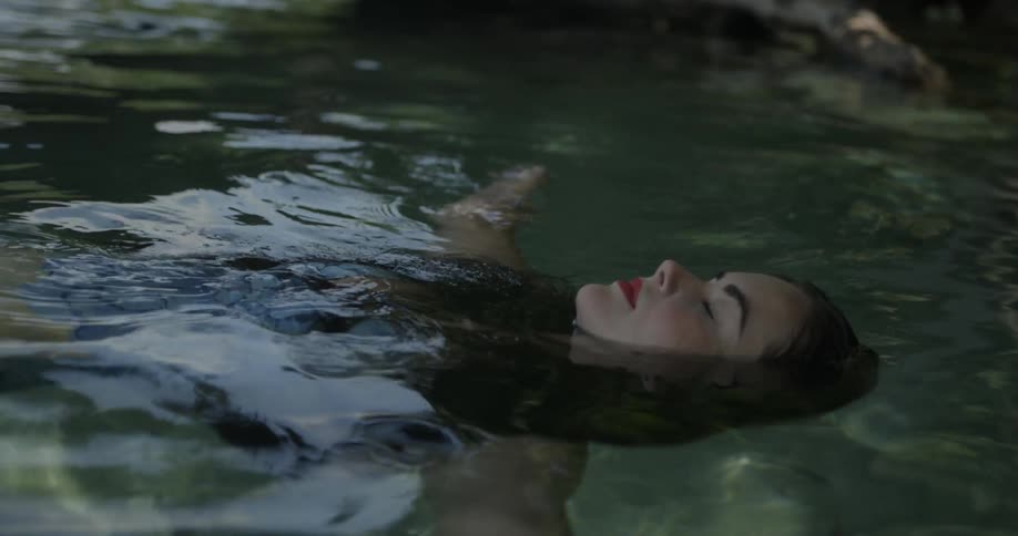 A woman floats on her back in a body of water