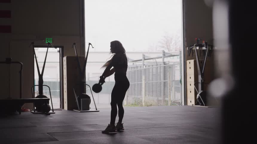 Woman exercising with kettlebell in a gym