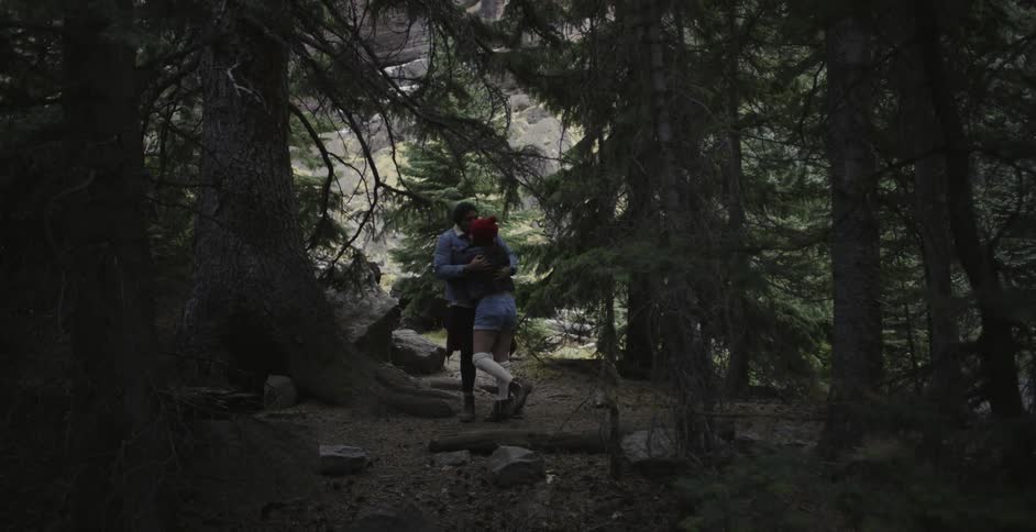 Two people hug in the woods