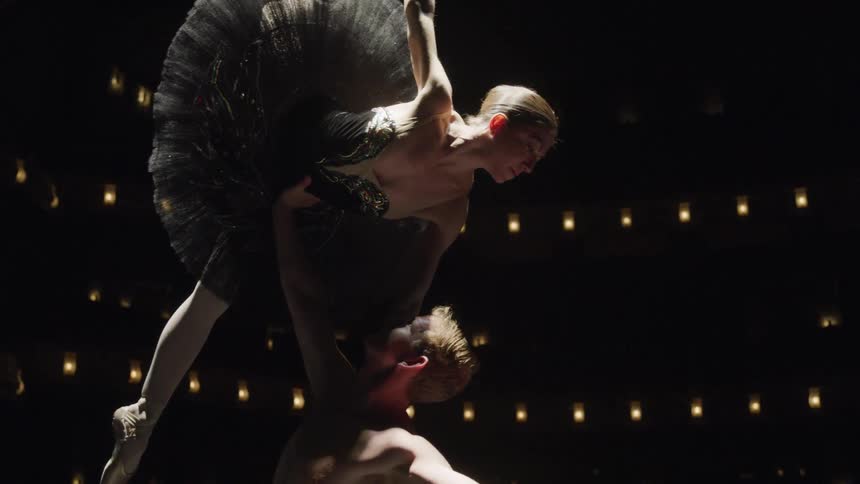 A ballerina is being held up in the air