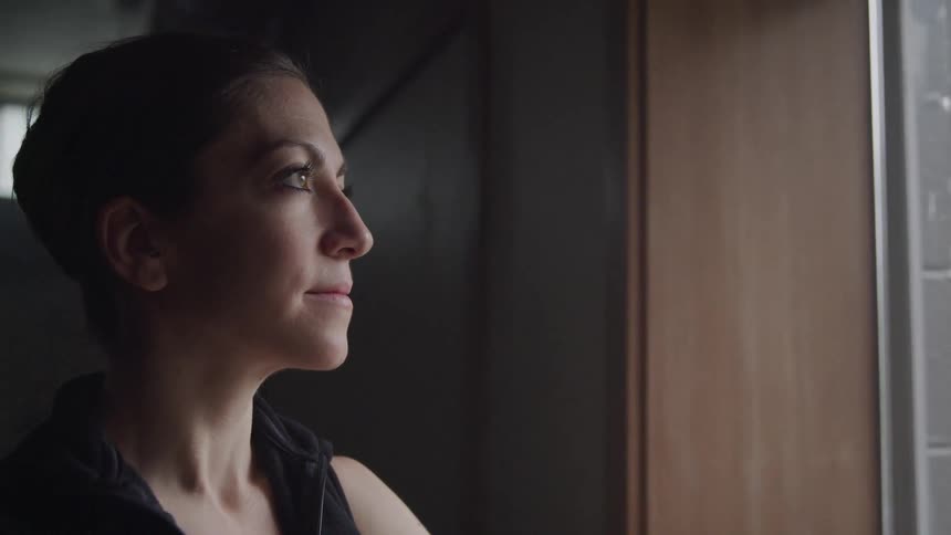 Portrait of a woman looking through a window