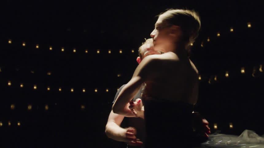 A dancer spins in the arms of another dancer