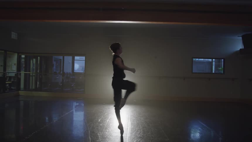 Ballerina in a ballroom practicing a turn for a performance