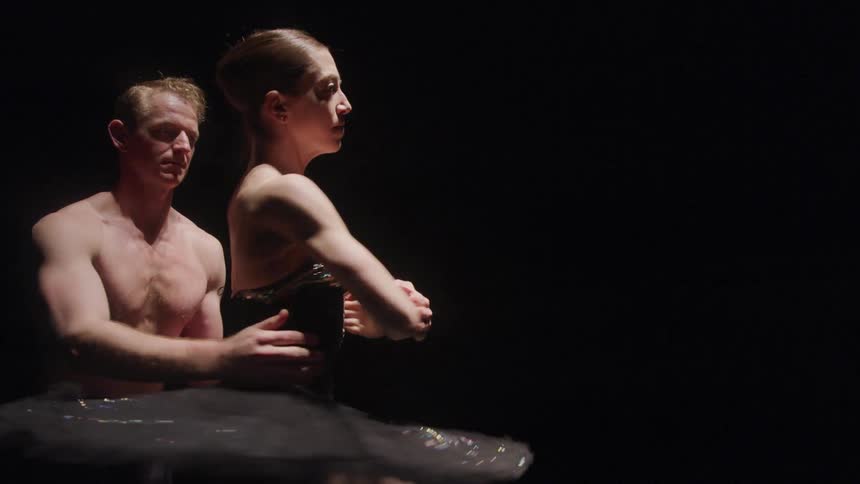 A woman and man dance ballet together