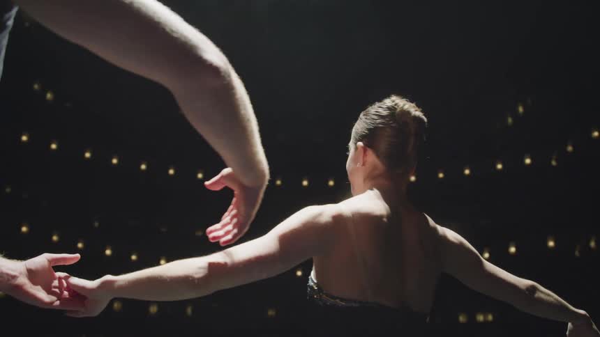 A man and woman are dancing together surrounded by lights