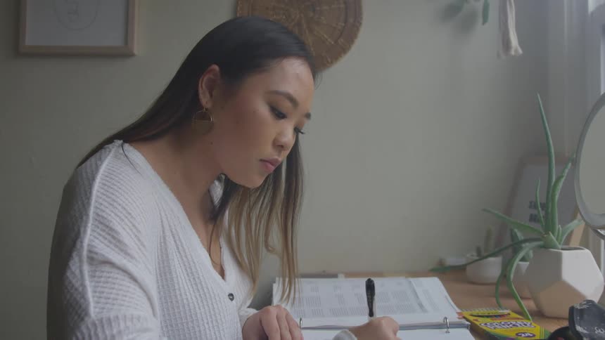 A woman is studying at her desk