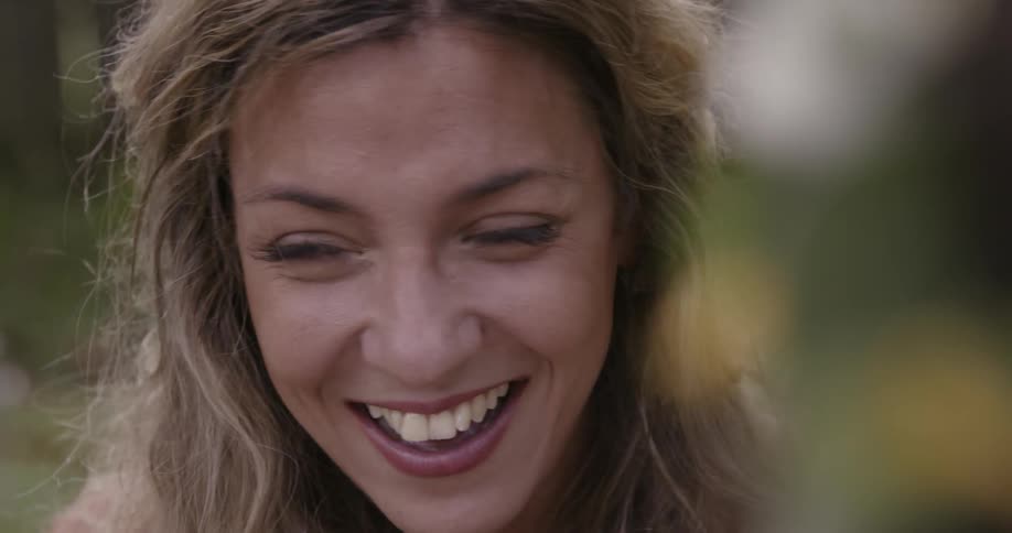 A woman laughs and turns her head