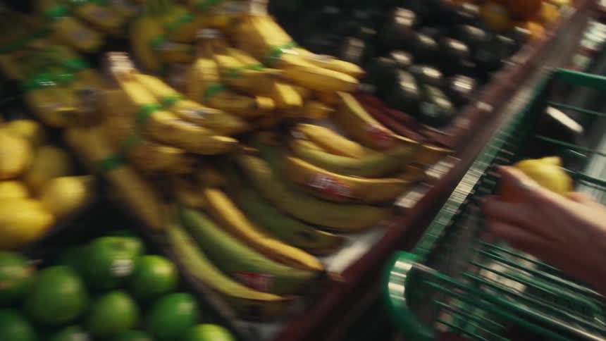 Hand picking up a sicilian lemon and putting it in the shopping cart