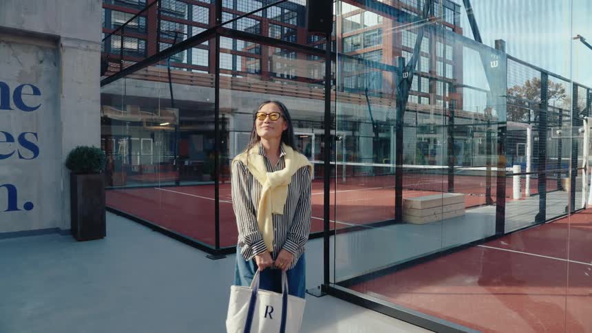 Woman with happy facial expression next to tennis court