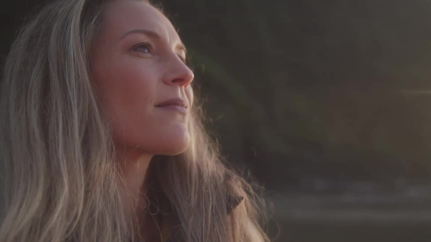 Portrait of a reflective woman while standing in an outdoor setting at dawn
