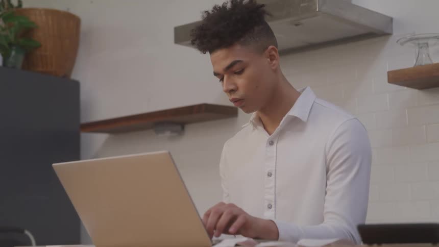 A man is typing on a laptop