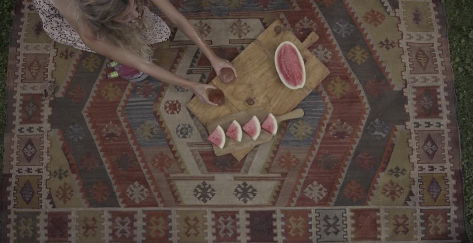 Two women setting up a picnic on a blanket