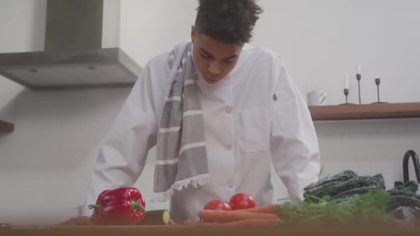 A man is looking at vegetables on the counter